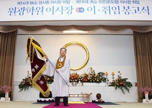 학교법인 원광학원 이사장 이·취임식에서 제15대 오은균 이사장이 원광학원 건학정신기를 흔들고 있다.